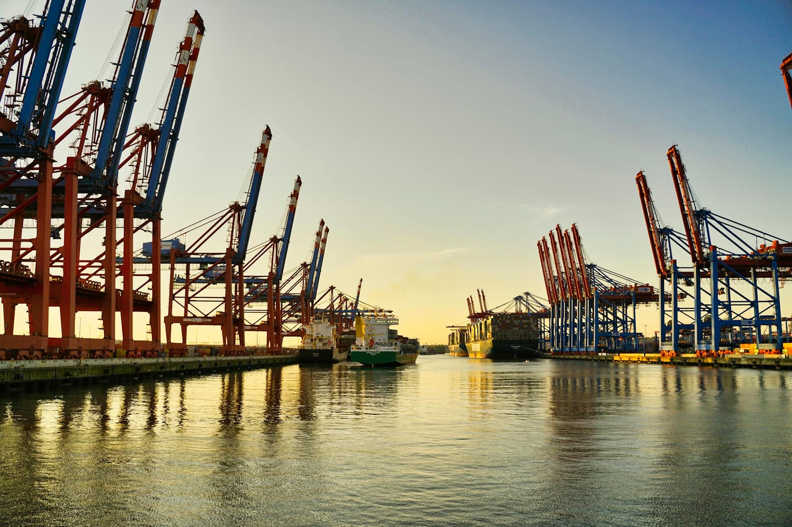 A European container port at dusk, gantry cranes along the quay, where stock arrives into the EU customs union.